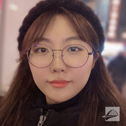 Seojung Jang headshot. Seojung is wearing a black puffer jacket and it is zipped all the way up to her neck. She is wearing a black knit winter hat and has round silver glasses on. She has long brown hair with bangs.