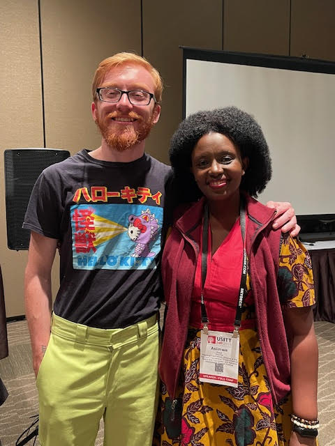 Sammy and Asiimwe standing together for a photo and smiling at USITT24