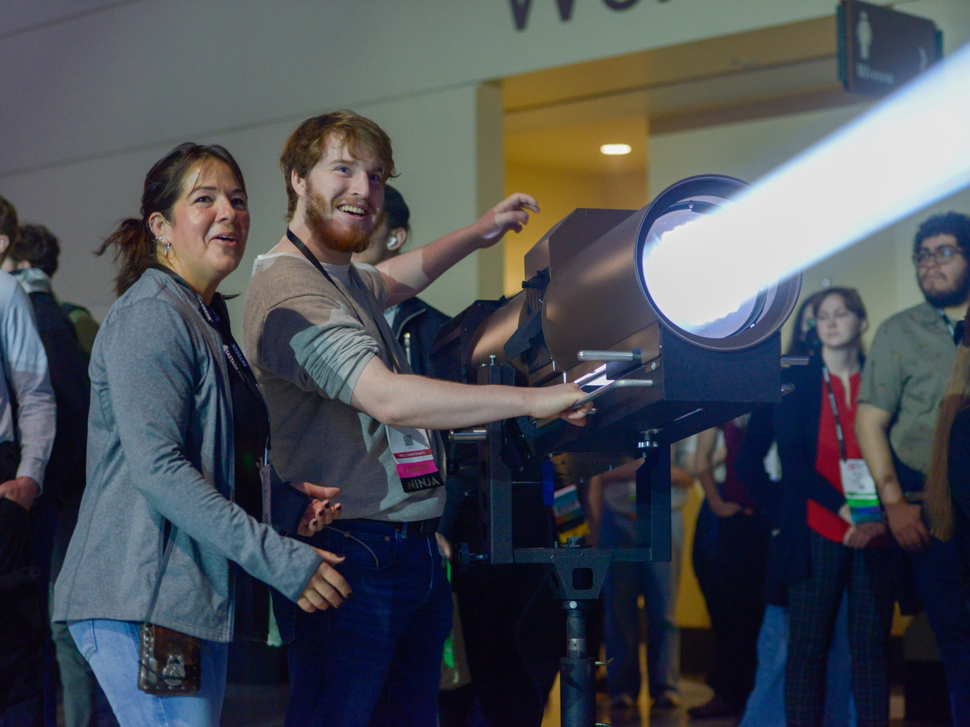 An Exhibitor leads an attendee in a hands-on experience with a spotlight